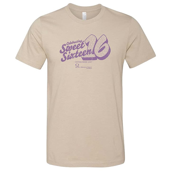 Grey shirt with Celebrating Sweet Sixteen in purple on the front with the QMG Foundation logo small at the bottom of the design
